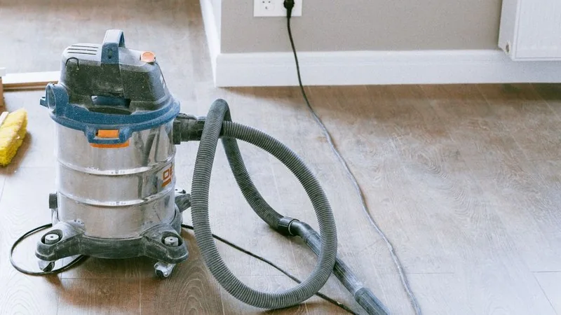 Dust-covered industrial vacuum cleaner on new timber flooring in a freshly renovated interior